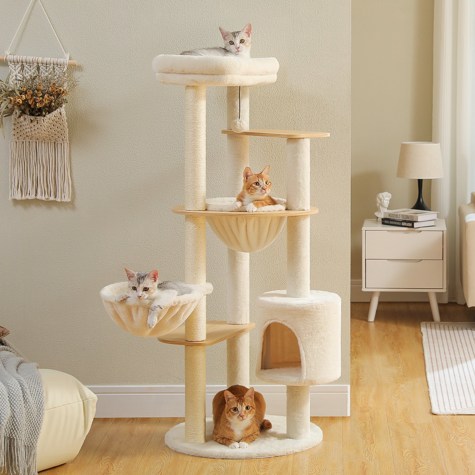 Beige multi-level cat tree with padded top perch, two hammocks, private condo, sisal posts, and cats resting in a bright living room