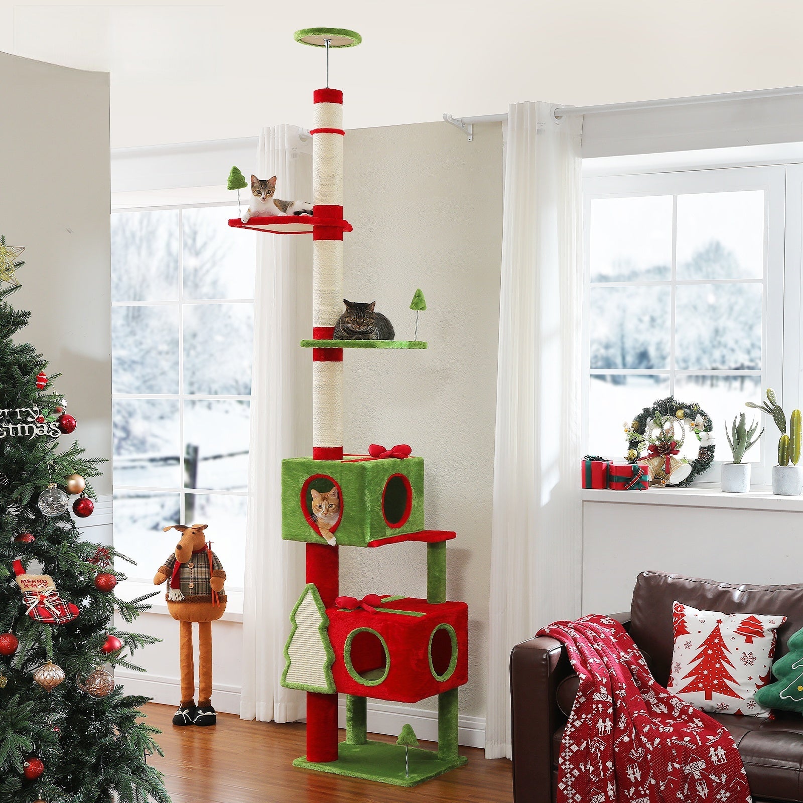 Festive red and green floor-to-ceiling cat tree with two private condos, sisal posts, platforms, and cats near a Christmas tree