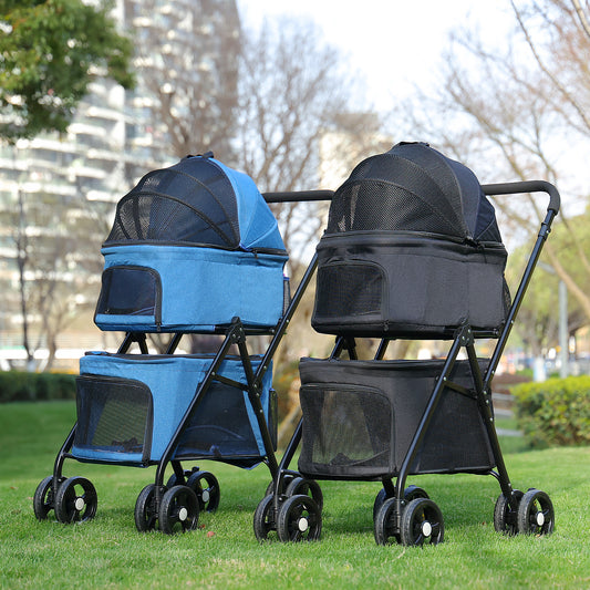 Two pet strollers, one blue and one black, on a grassy area with trees and buildings in the background.