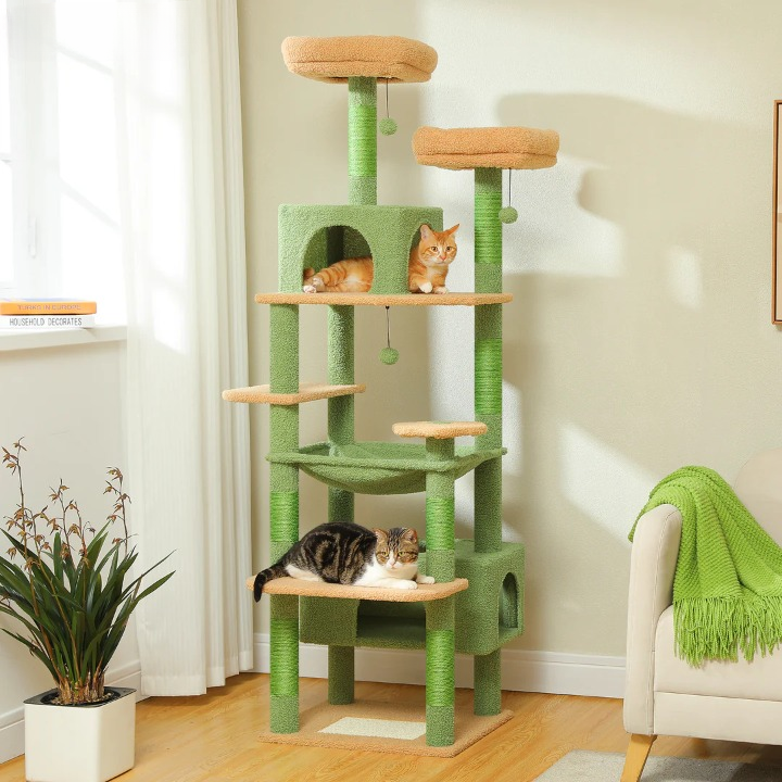 Green and brown cat tree with two cats in a room with a plant and chair.