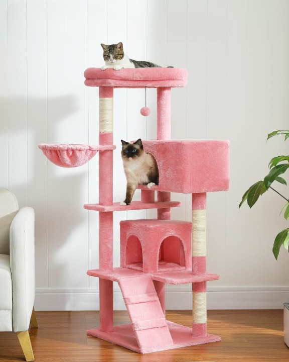 Pink cat tree with two cats on a wooden floor.