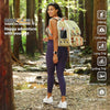 Woman in a forest with a pet backpack, surrounded by nature.