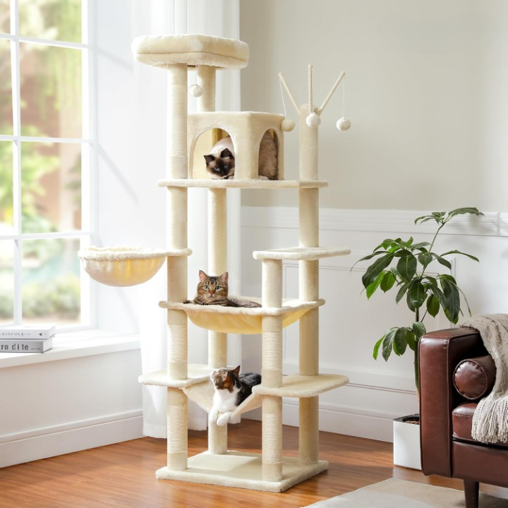 Cat tree with multiple levels and a cat resting on one of the shelves in a room with a window and plant.