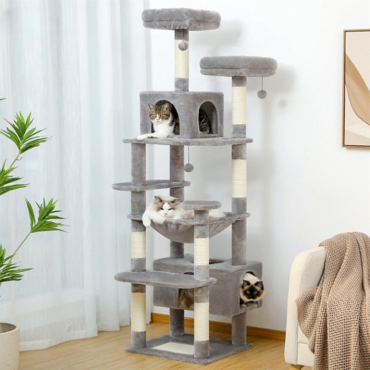 Cat tree with multiple levels and a cat sitting on one of the platforms in a room.